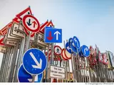 Zahlreiche Verkehrsschilder stehen dicht zusammen
